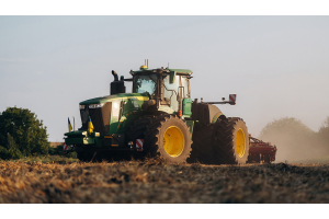 Green John Deere tractor working in field