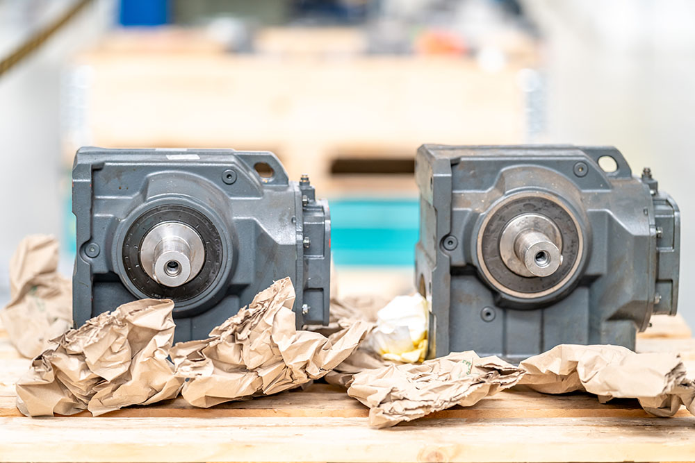 Two hydraulic pumps sitting on a shop shelf