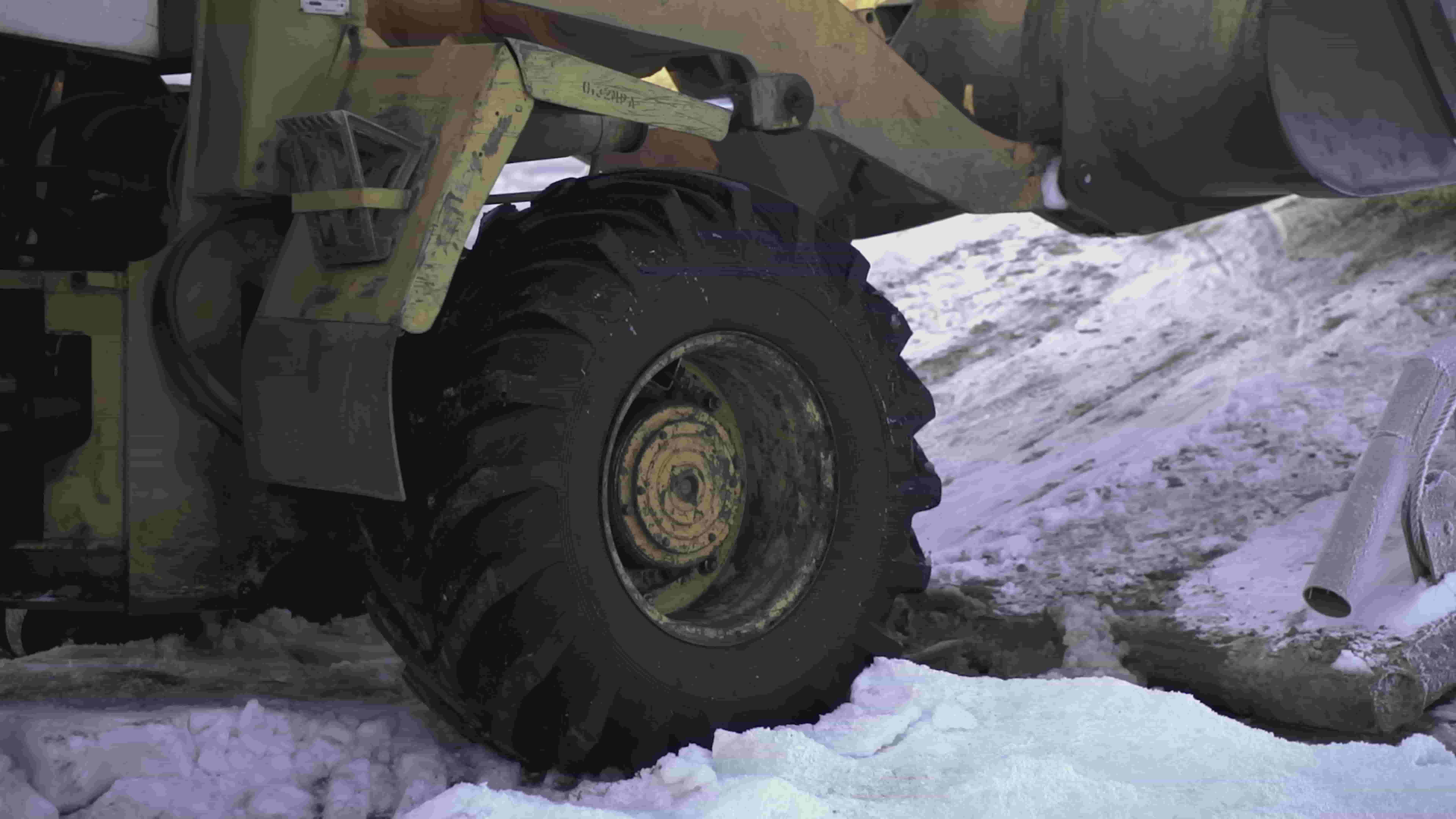 Wheel of bulldozer working in snowy conditions