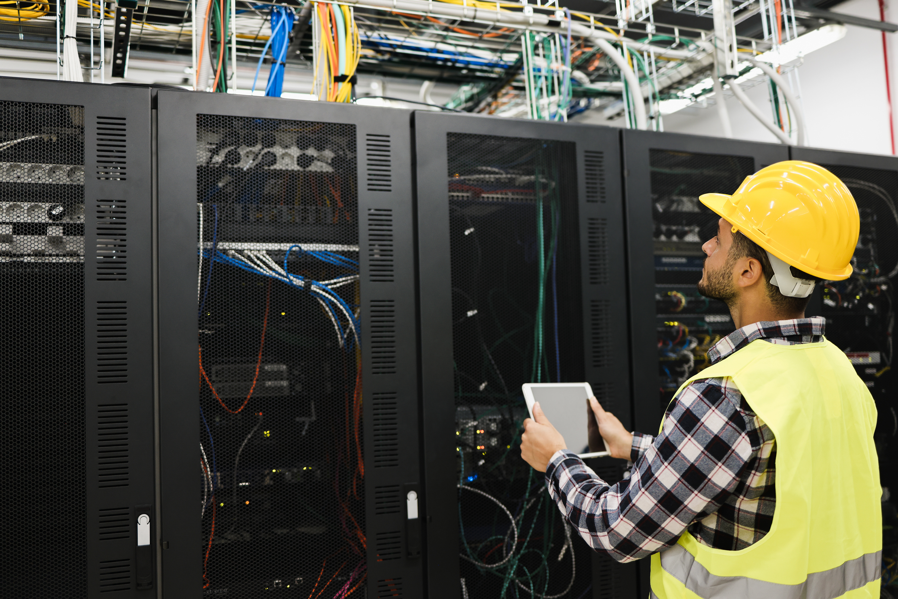 technician working inside a data center with tablet